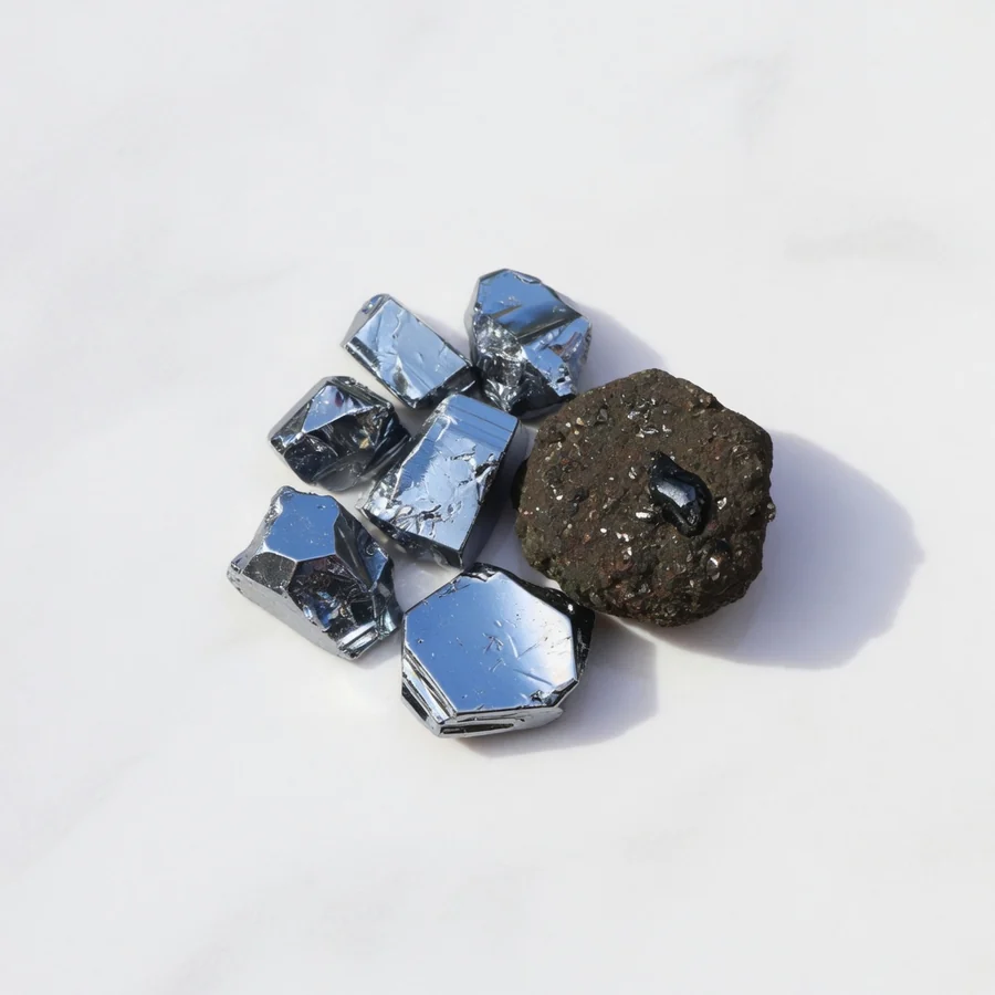 Srebrzystoszare grudki chromu o metalicznym połysku obok minerału chromitu